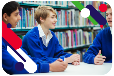 Three young people in a school library sit at a table having an animated discussion