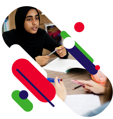 Close up of a young person mid sentence as they discuss their work at school. They have pens and notebooks on their desk. 