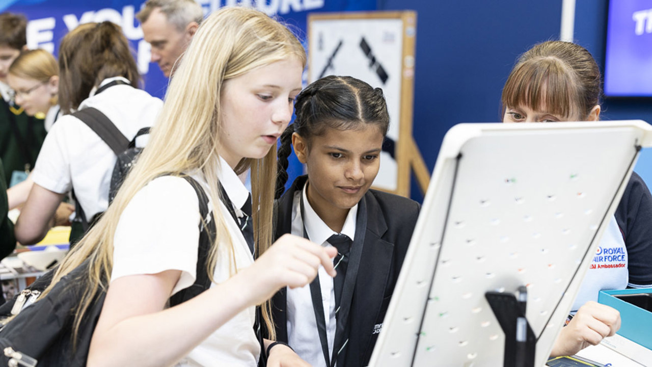 Young people interact with exhibits and stands and activities at The Big Bang Fair